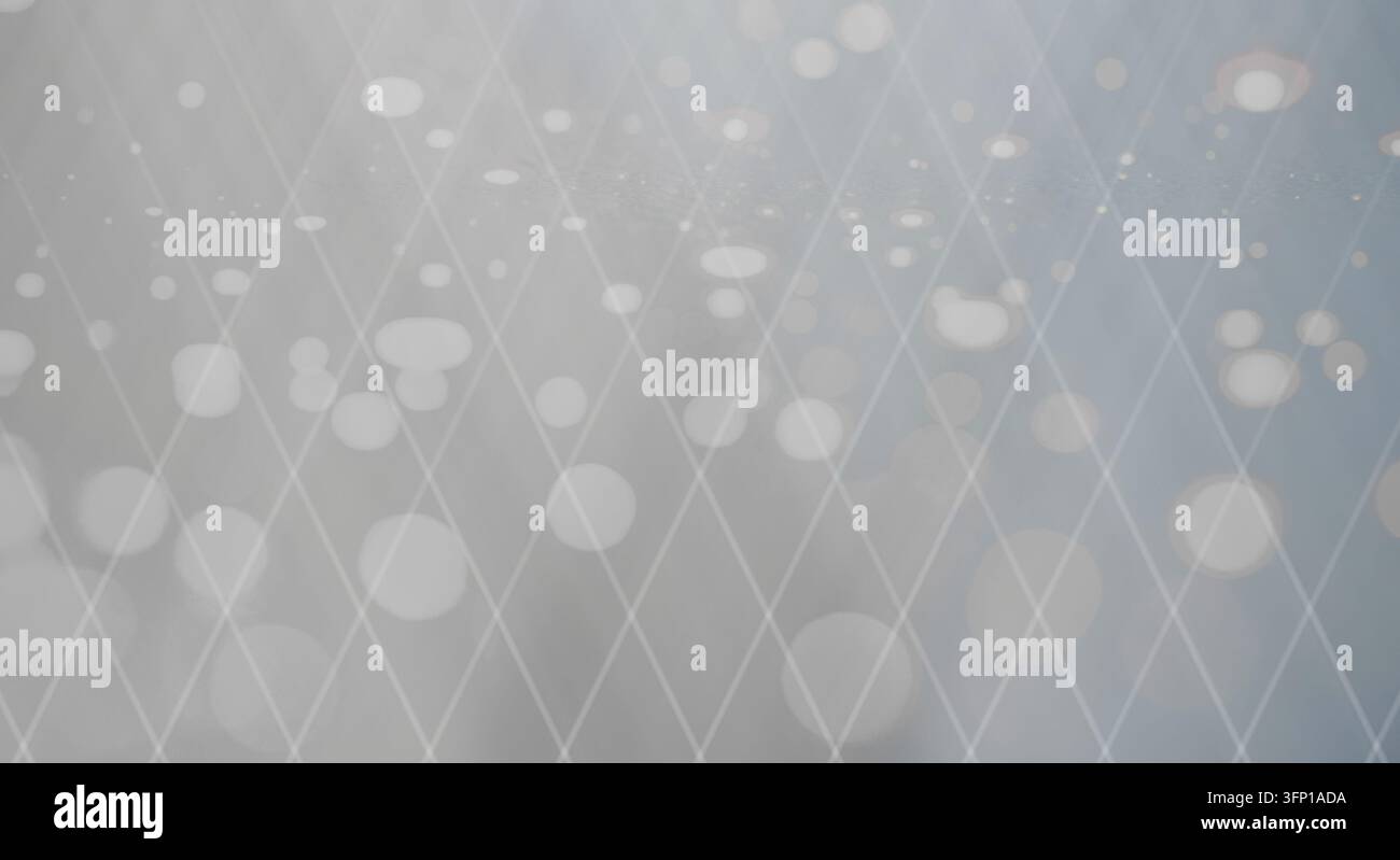 Ein weich gezeichneter grauer Hintergrund mit einem dezenten Diamantgitter und leuchtenden Bokeh-Kreisen. Stockfoto