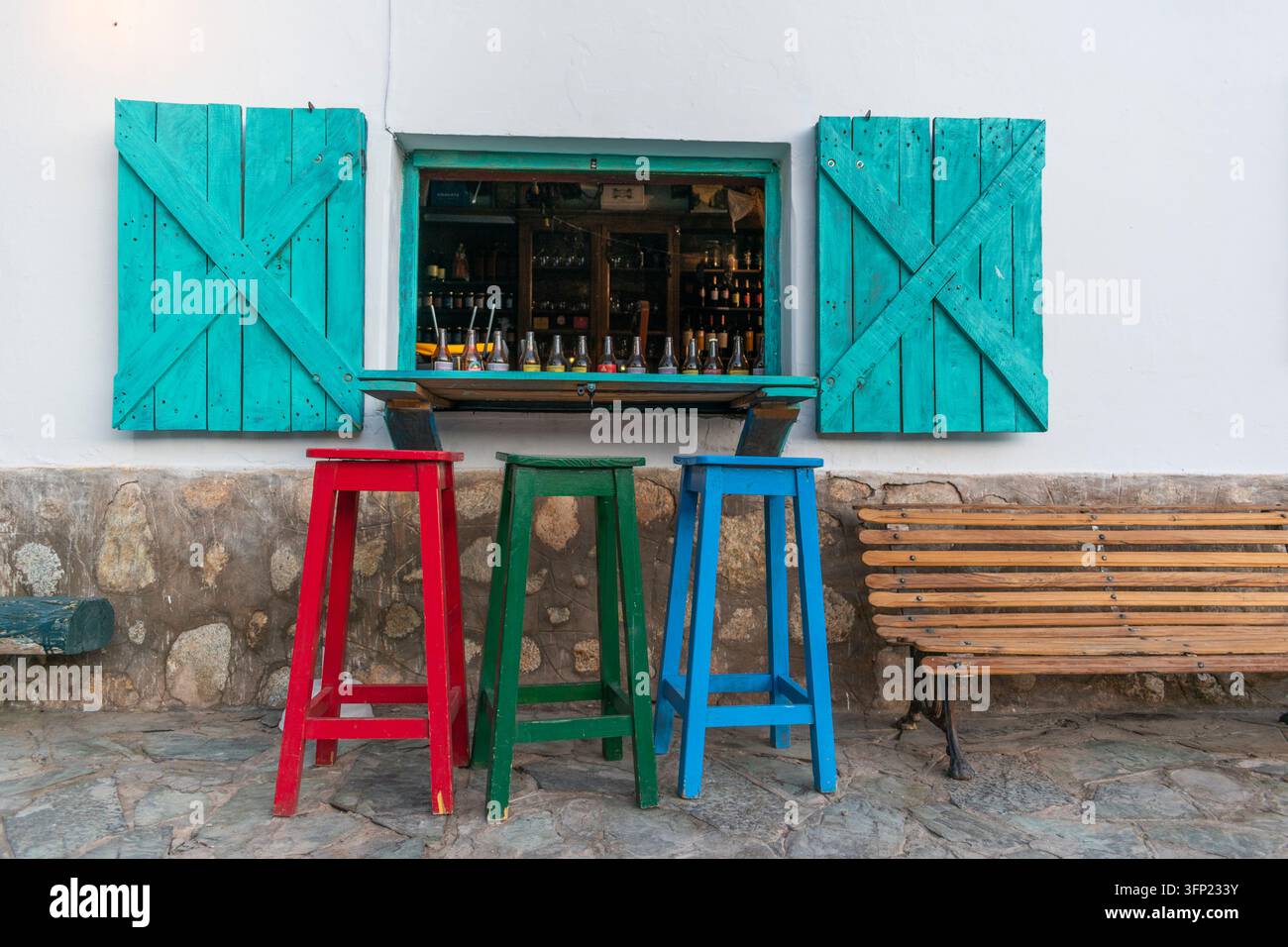 Farbenfrohes Fenster mit türkisfarbenen Fensterläden und Hockern in Cachi, Salta, Argentinien Stockfoto