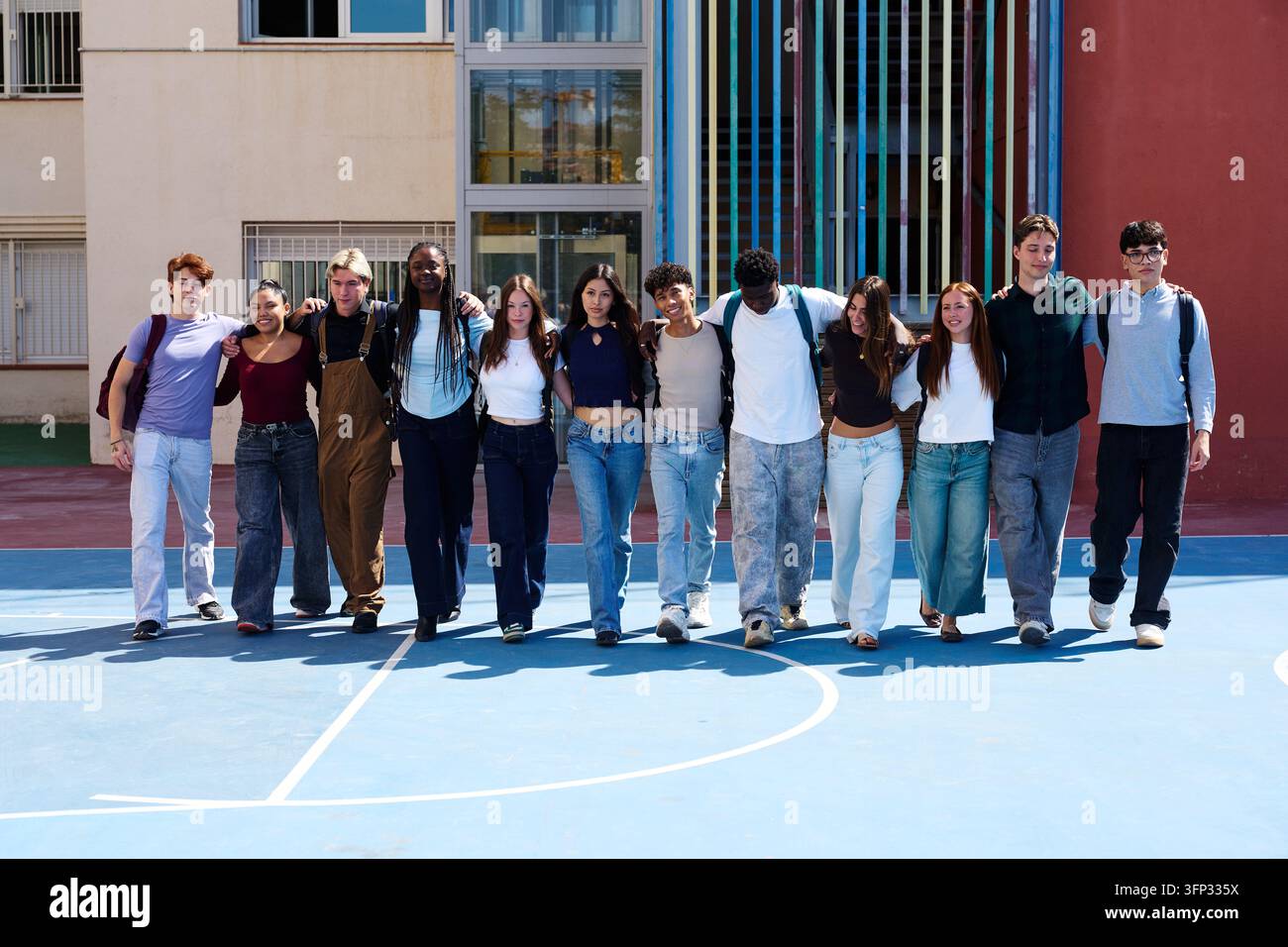 Gruppe verschiedener Teenager, die Arm in Arm gehen und Freundschaft, Einheit und Unterstützung in der Bildung symbolisieren Stockfoto