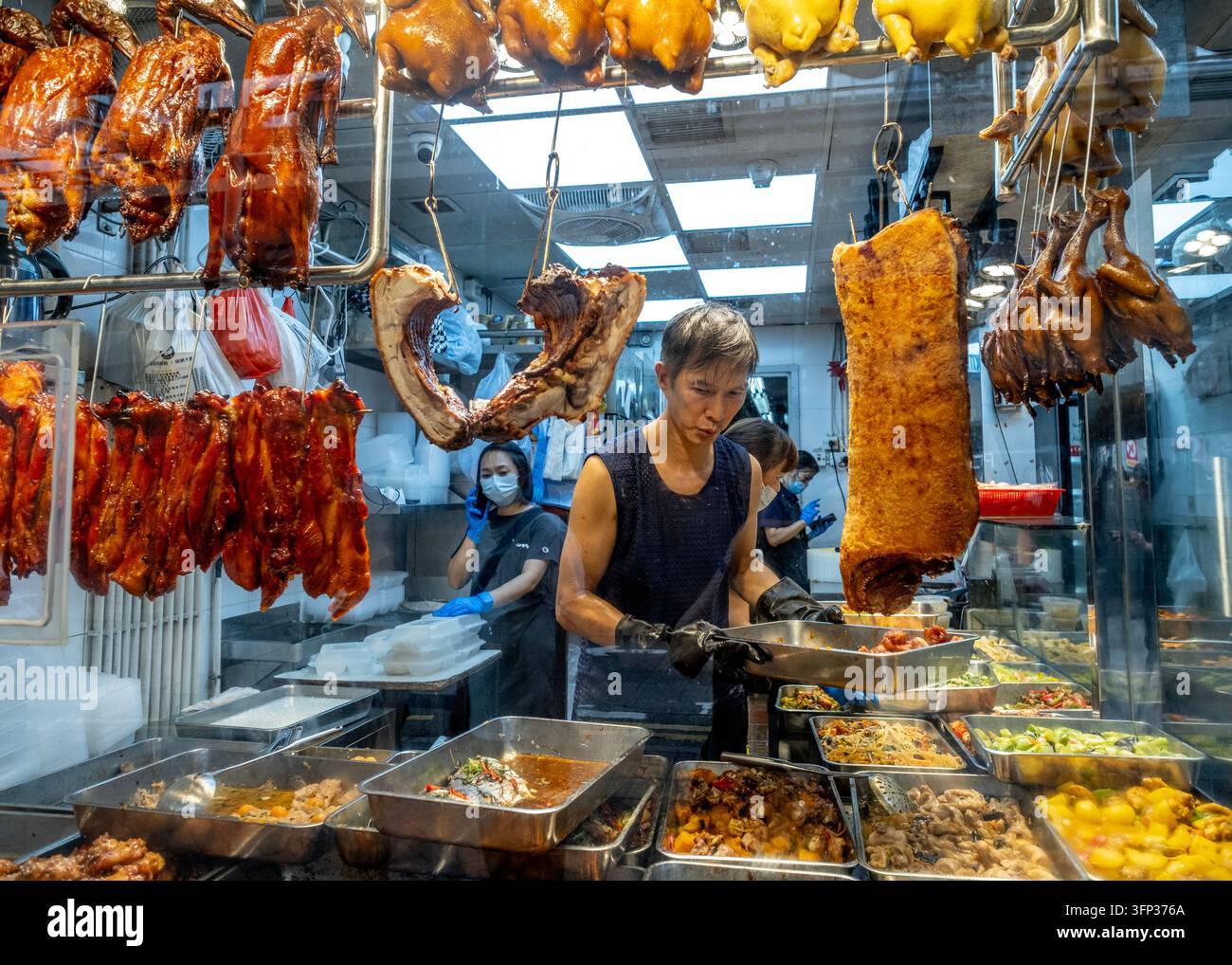 Verkäufer bereiten gekochte Speisen auf dem Bowrington Road Wet Market in Wan Chai, Hong Island, zu. Stockfoto