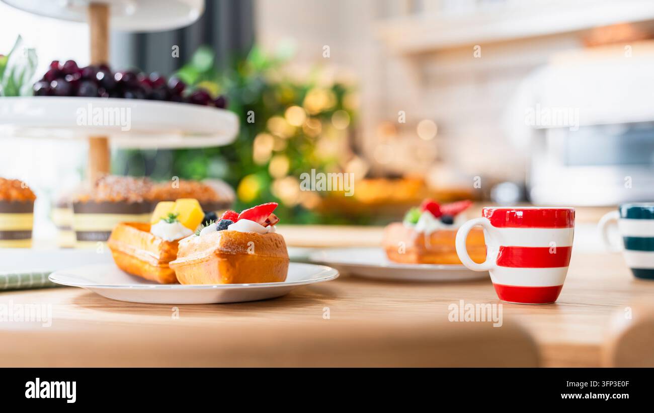 Frisch gebackenes Waffel-Dessert und Café-Frühkonzept, knusprige Waffeln mit Schlagsahne und Beeren auf dem Teller neben gestreifter Kaffeetasse Stockfoto