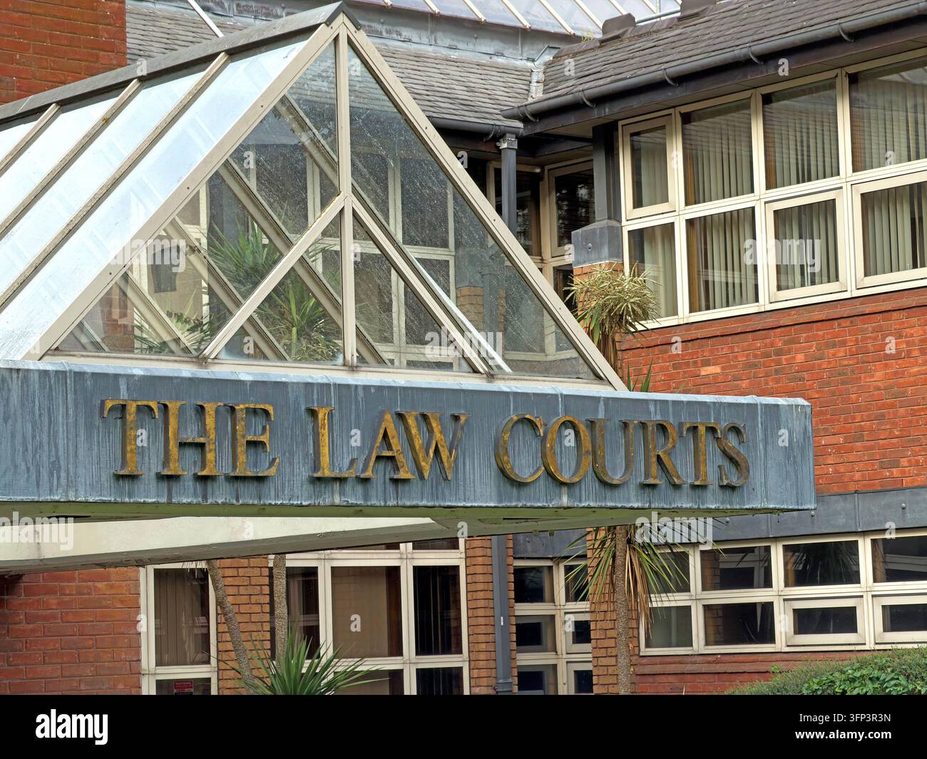 Ein Schild mit der Aufschrift THE LAW COURTS ist unter einem verglasten Eingangsvorbau an einem Backstein-Gebäude der Stadtverwaltung angebracht. Stockfoto