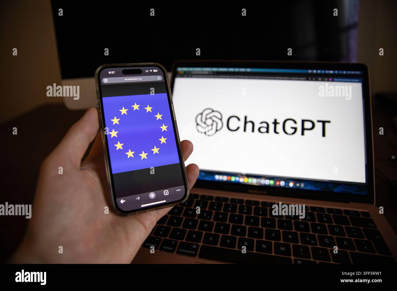 Das ChatGPT-Logo und die Benutzeroberfläche werden auf Apple-Geräten zusammen mit der Flagge der Europäischen Union in Berlin, Deutschland, am Dienstag, dem 6. Oktober 2026, angezeigt. OpenAI kündigte am 5. Oktober an, dass es in den kommenden Wochen für bestimmte ChatGPT- und Codex-Ausgaben in der Europäischen Union unsichtbare Textwasserzeichen einführen wird, als Teil seiner Reaktion auf die Transparenzanforderungen gemäß der EU-KI-Richtlinie. Die Technologie, textGrain genannt, fügt ein statistisches Signal durch die Wortwahl der Modelle ein, anstatt sichtbare Markierungen oder versteckte Zeichen hinzuzufügen. OpenAI sagte, das System sei dazu gedacht, KI-generierten Text maschinell Stockfoto