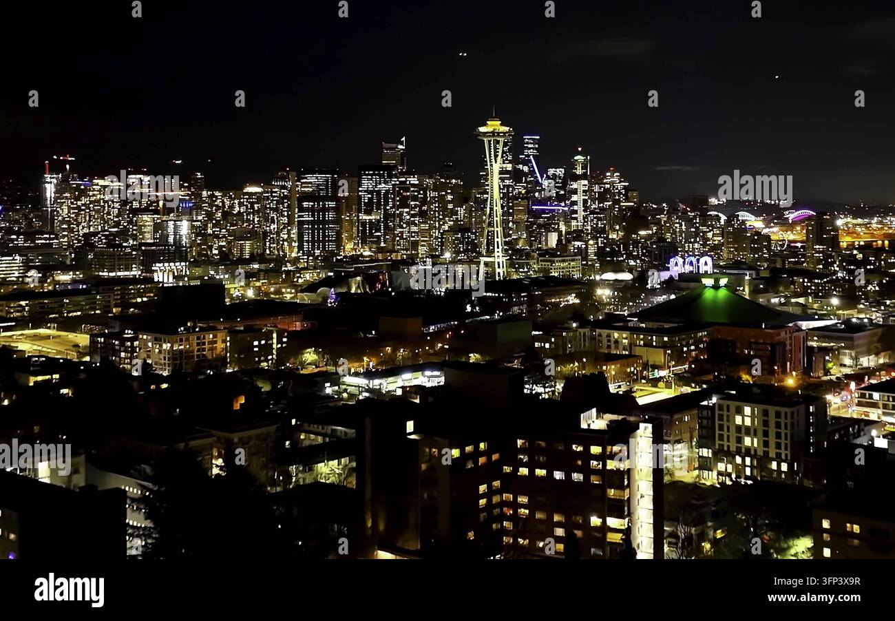 Luftbild des beleuchteten Space Needle bei Nacht inmitten der leuchtenden Wolkenkratzer und städtischen Lichter der Innenstadt von Seattle, WA, Vereinigte Staaten. Stockfoto