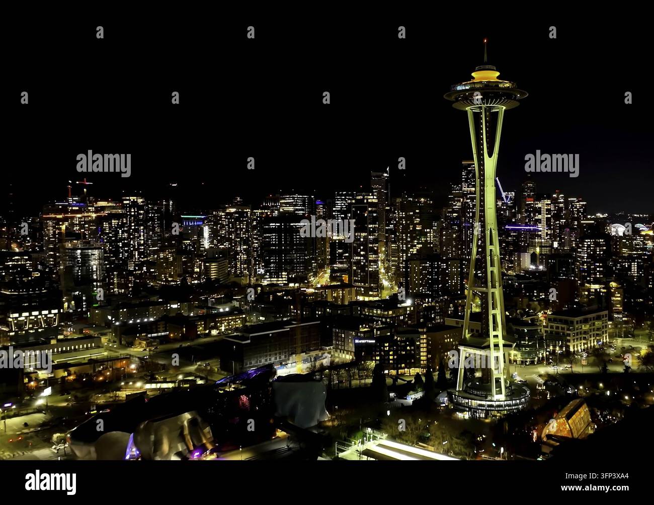 Luftbild des Space Needle bei Nacht, beleuchtet mit der leuchtenden Skyline von Seattle im Hintergrund, Seattle, WA, Vereinigte Staaten. Stockfoto