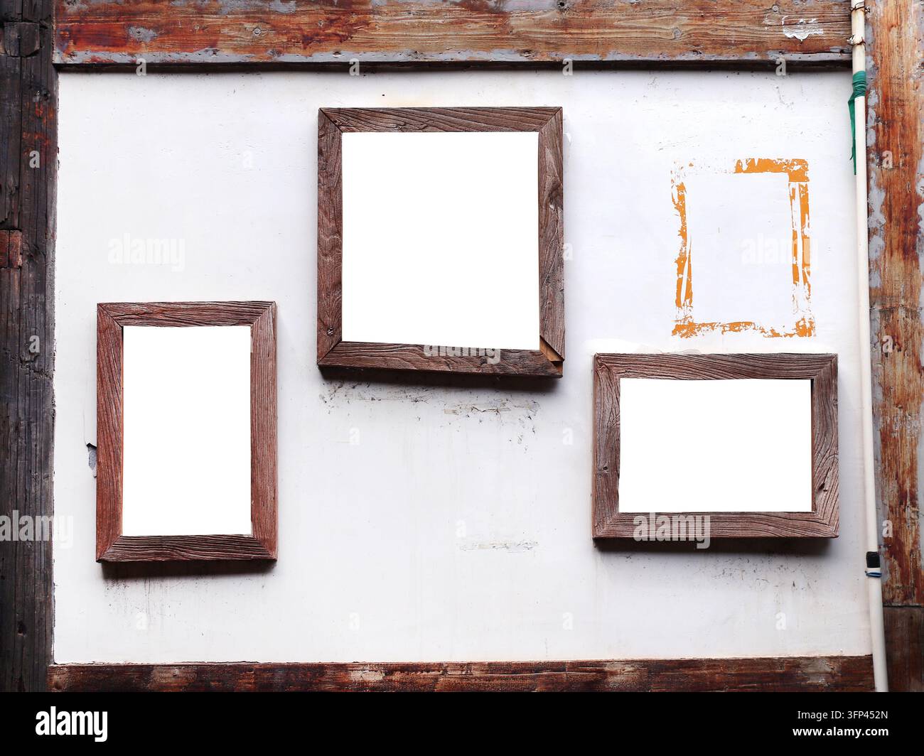 Drei Retro-Holz-Bilderrahmen auf alter Stuckwand. Leere Vintage-Rahmen an einer Loft-Stil weißen Stuckwand. Posterrahmen hängen an rustikaler Textur Stockfoto