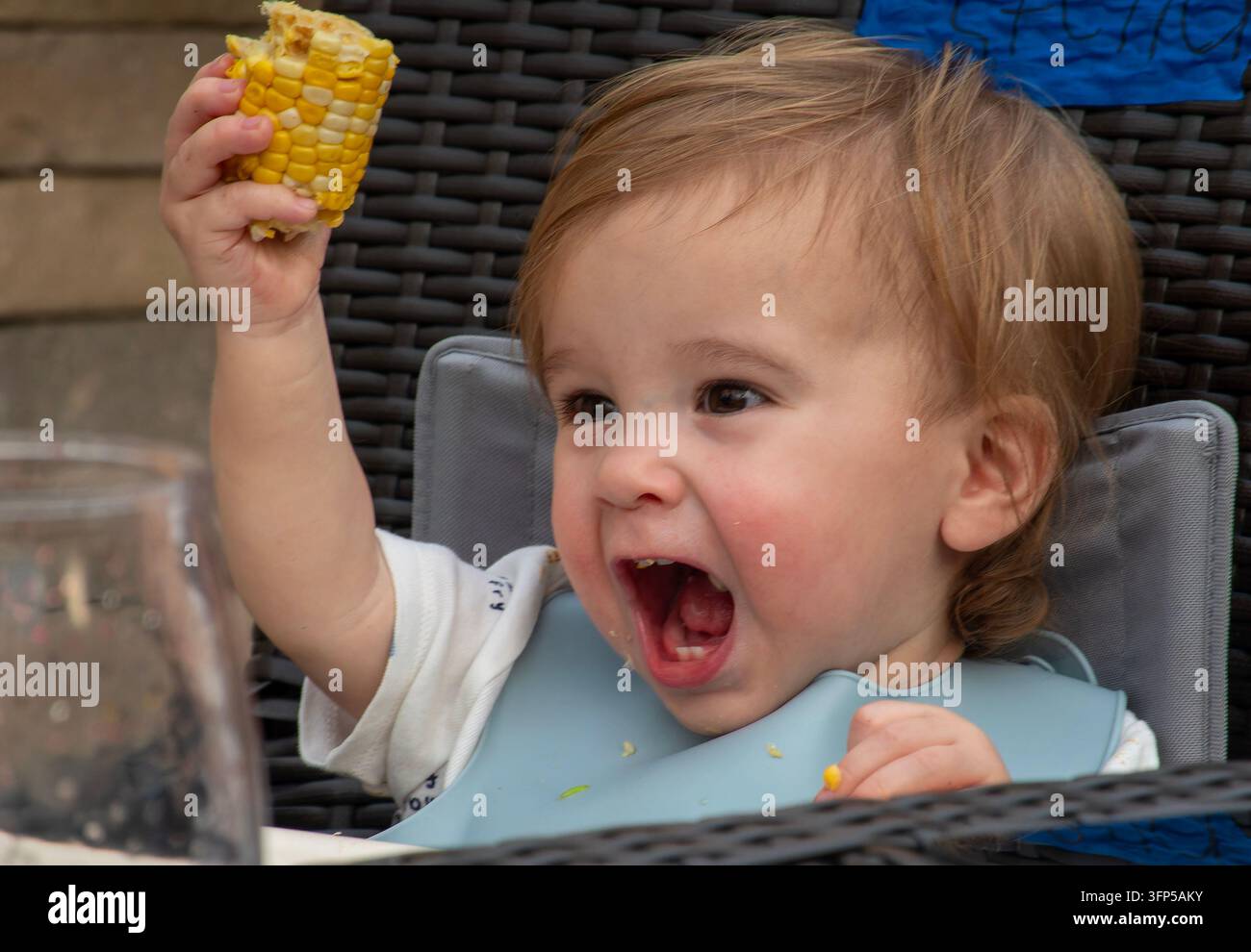 Ein Kleinkind, das sich am Tisch vergnügt. Stockfoto