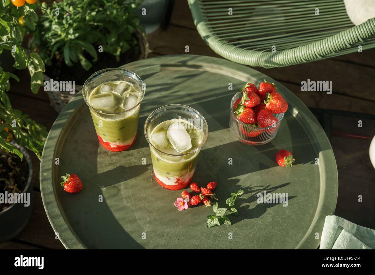 Erdbeer-Matcha-Lattes auf einem Sommergartentisch, Ansicht von oben Stockfoto