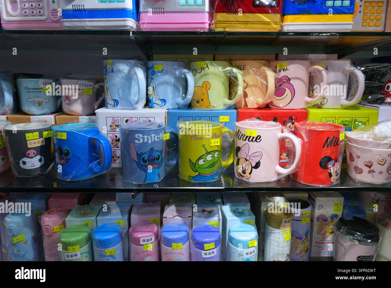 HONGKONG, CHINA - 5. NOVEMBER 2025: Regale eines Spielzeugladens in Hongkong. Trinkbecher mit lizenzierten Disney-Figuren: Donald Duck, Winnie the Stockfoto