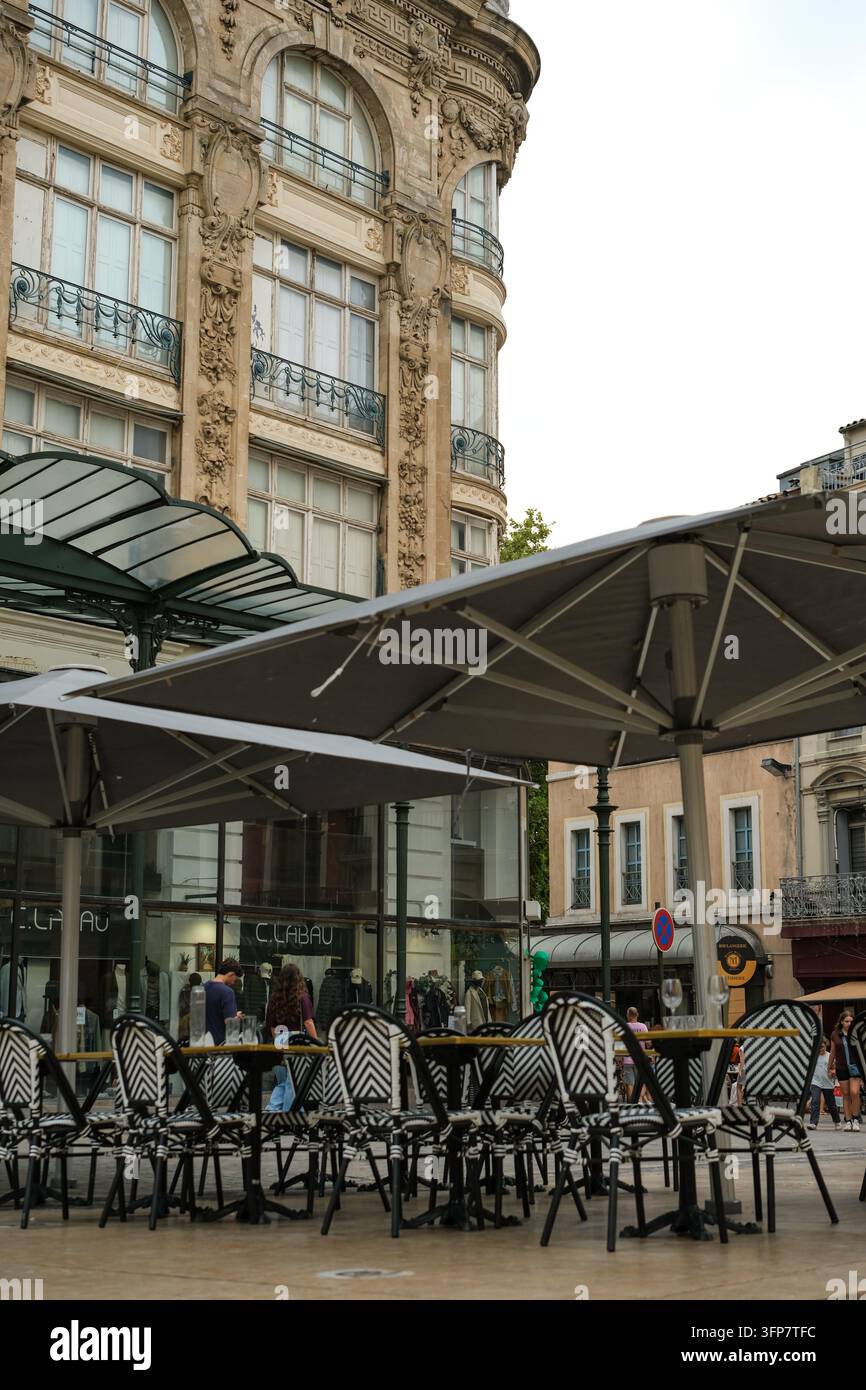 Narbonne, Okzitanien, Frankreich. 26. August 2026. Straßencafé unter kunstvoller Architektur im historischen Zentrum von Narbonne. Stockfoto