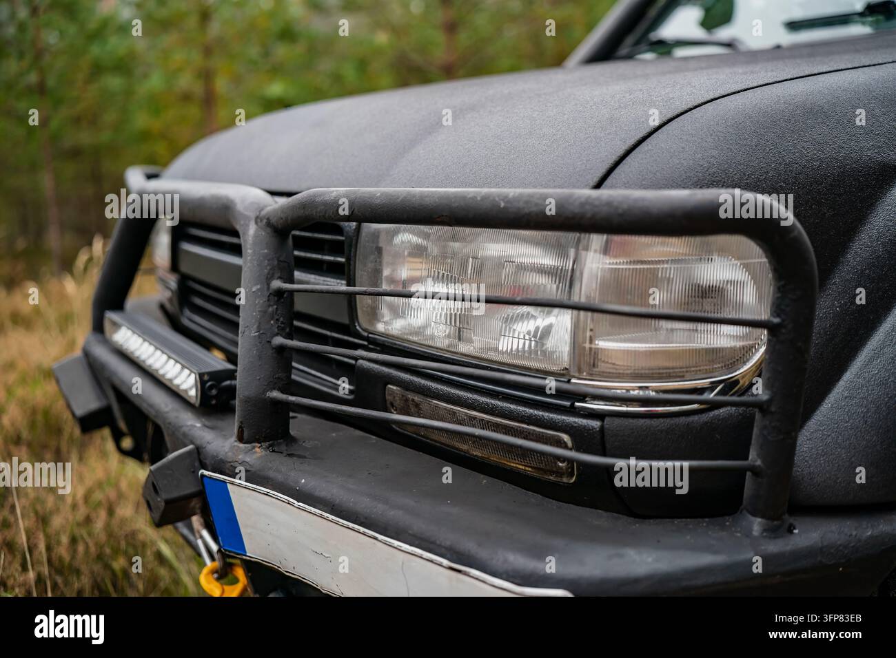 Geländewagen-SUV-Scheinwerfer hinter einer röhrenförmigen Bullenstütze mit zusätzlicher LED-Stange und verstärkter Stoßstange, zeigt Frontschutzzubehör für Freizeitfahrzeuge Stockfoto