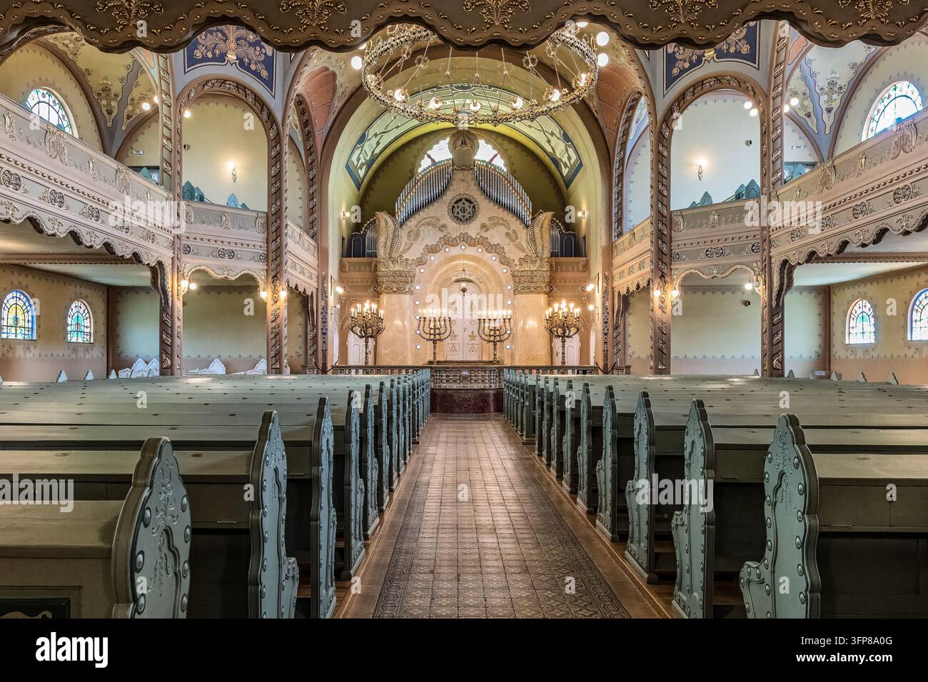 Blick den Mittelgang hinunter zum Torarahschrank (Aron Kodesh), flankiert von großen Menorahen, als Mittelpunkt des jüdischen Gebets, Synagoge in Subotica, Serbien Stockfoto
