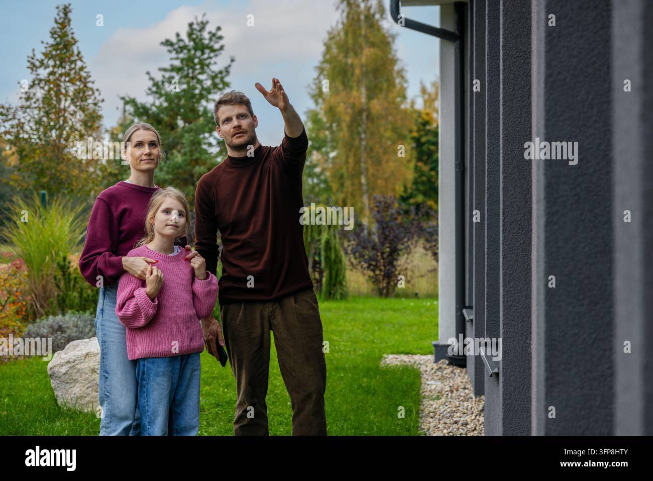 Familie betrachtet ein modernes neues Haus vor dem Kauf Stockfoto