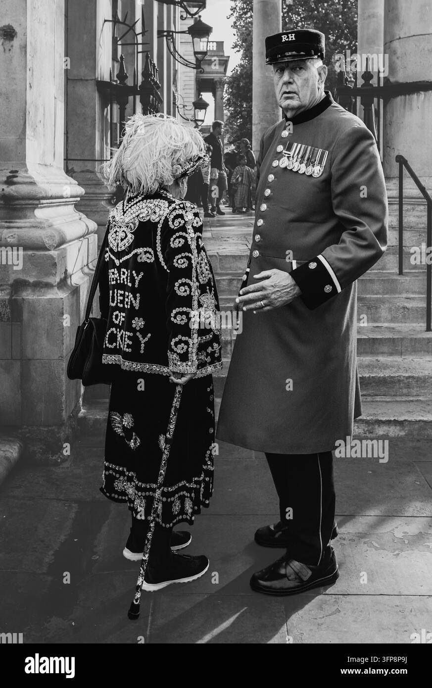 Traditionelle Londoner Perlenköniglichkeit in ihrem dekorierten Perlmuttanzug unterhält sich mit einem Chelsea-Pensionär beim Erntefest im Zentrum Londons. Stockfoto