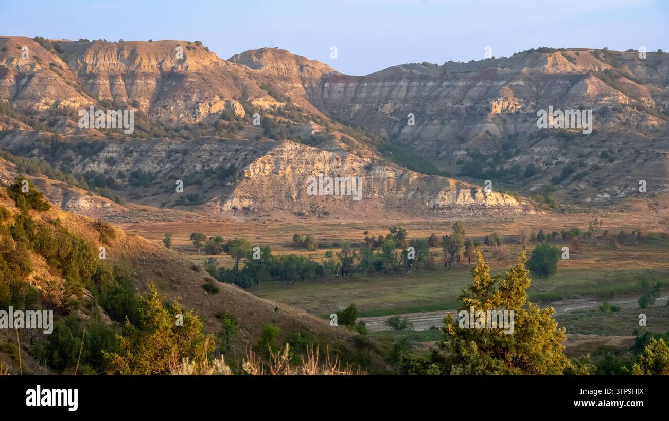 Schichtige Badlands-Buttes und Flusstal im goldenen Morgenlicht, Theodore Roosevelt Nationalpark, North Dakota. Stockfoto