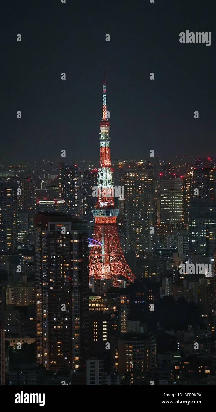 Luftbild des beleuchteten Tokyo Tower bei Nacht, umgeben von der dichten städtischen Skyline von Minato City, Tokio, Japan. Stockfoto