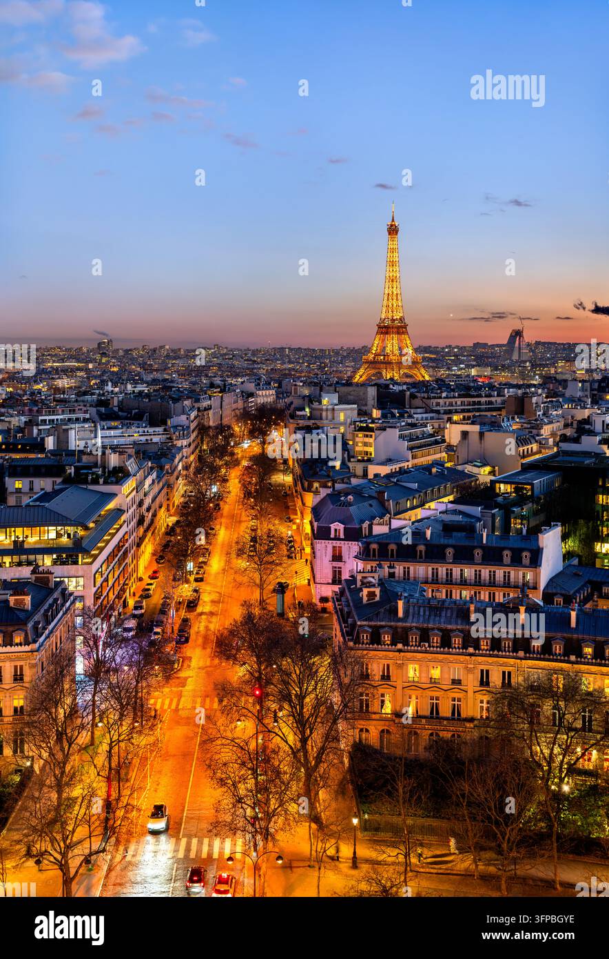 Paris, Frankreich - 04. Januar 2026: Erhöhte Ansicht des beleuchteten Eiffelturms und des Pariser Straßenverkehrs in der Dämmerung vom Arc de Triomphe aus. Stockfoto