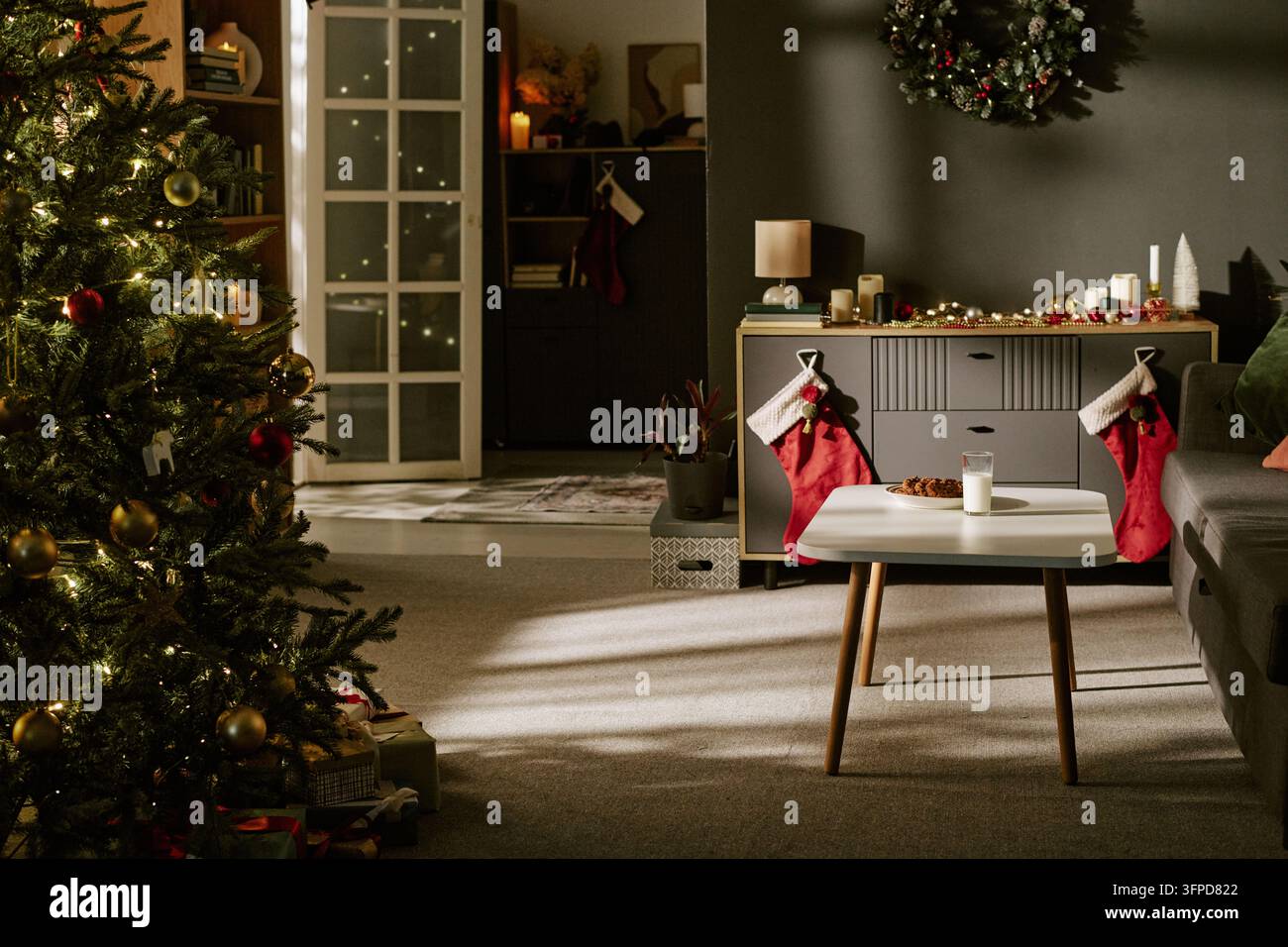 Dekorierter gemütlicher Wohnraum mit Weihnachtsbaum für die Feiertagszeit Stockfoto