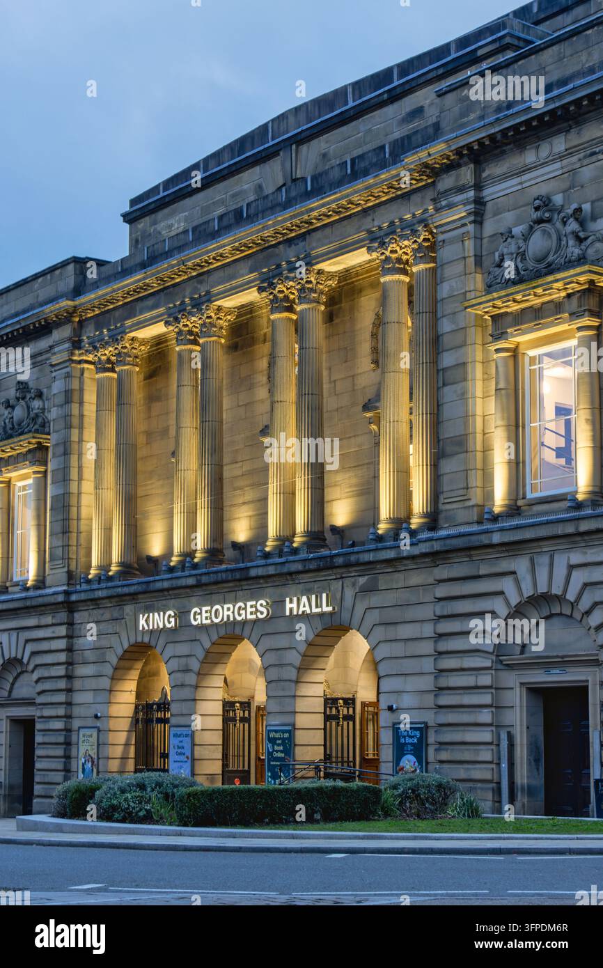 Portraitformatige Bodenebenenphotographie zeigt die gesamte Hauptfassade des King Georges Hall in Blackburn, Lancashire, bei Einbruch der Dämmerung aufgenommen. Stockfoto