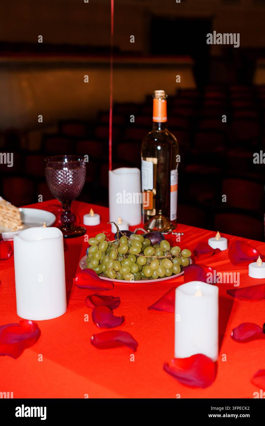 Intime Essensordnung mit weißen Kerzen und Glasgeschirr, die eine romantische Atmosphäre für ein Abendessen-Date-Konzept schafft Stockfoto