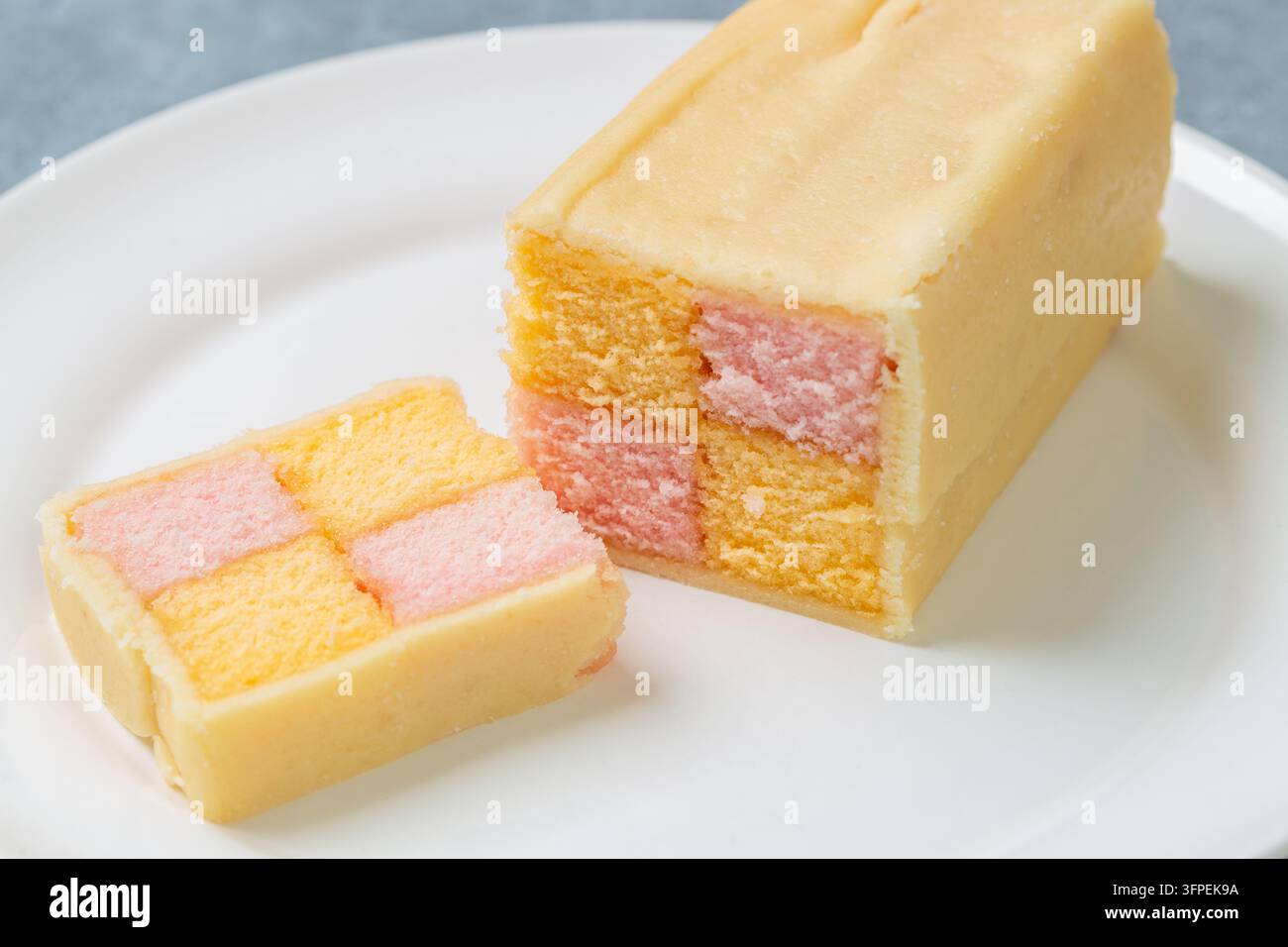 Scheiben eines traditionellen Battenberg-Kuchens, ein klassischer britischer Biskuitkuchen mit einem rosa-gelb karierten Muster Stockfoto