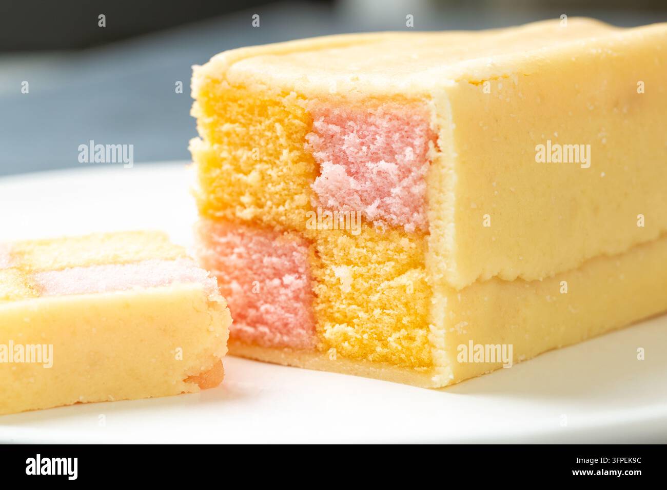 Scheiben eines traditionellen Battenberg-Kuchens, ein klassischer britischer Biskuitkuchen mit einem rosa-gelb karierten Muster Stockfoto