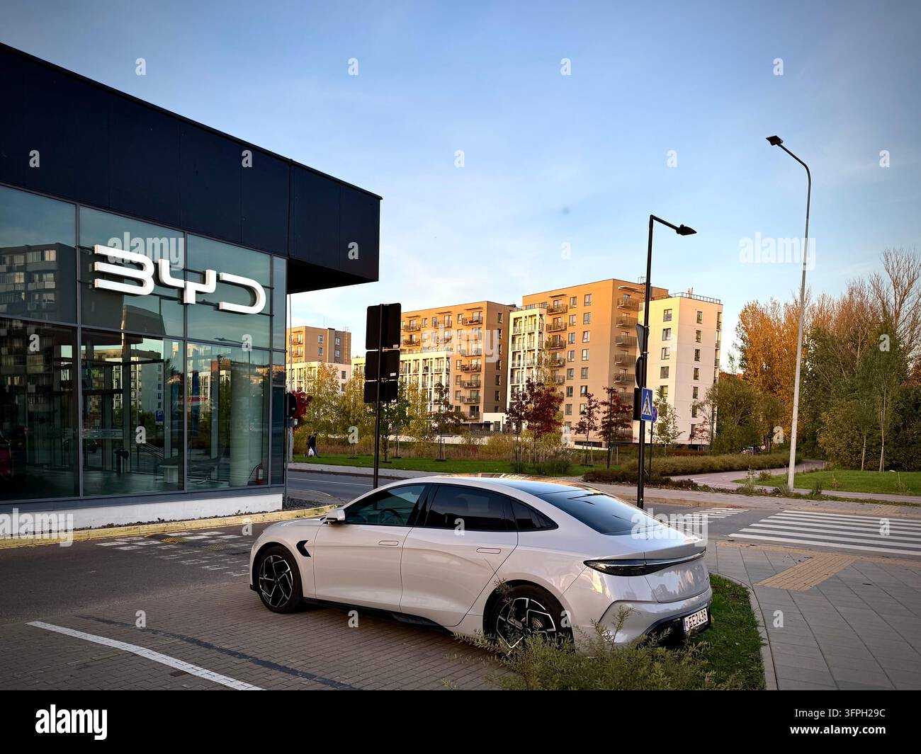 Ein modernes BYD-Autohandelsgeschäft mit weiß beleuchteter BYD-Logo-Schilderei - Smartphone-aufgenommenes Stockfoto