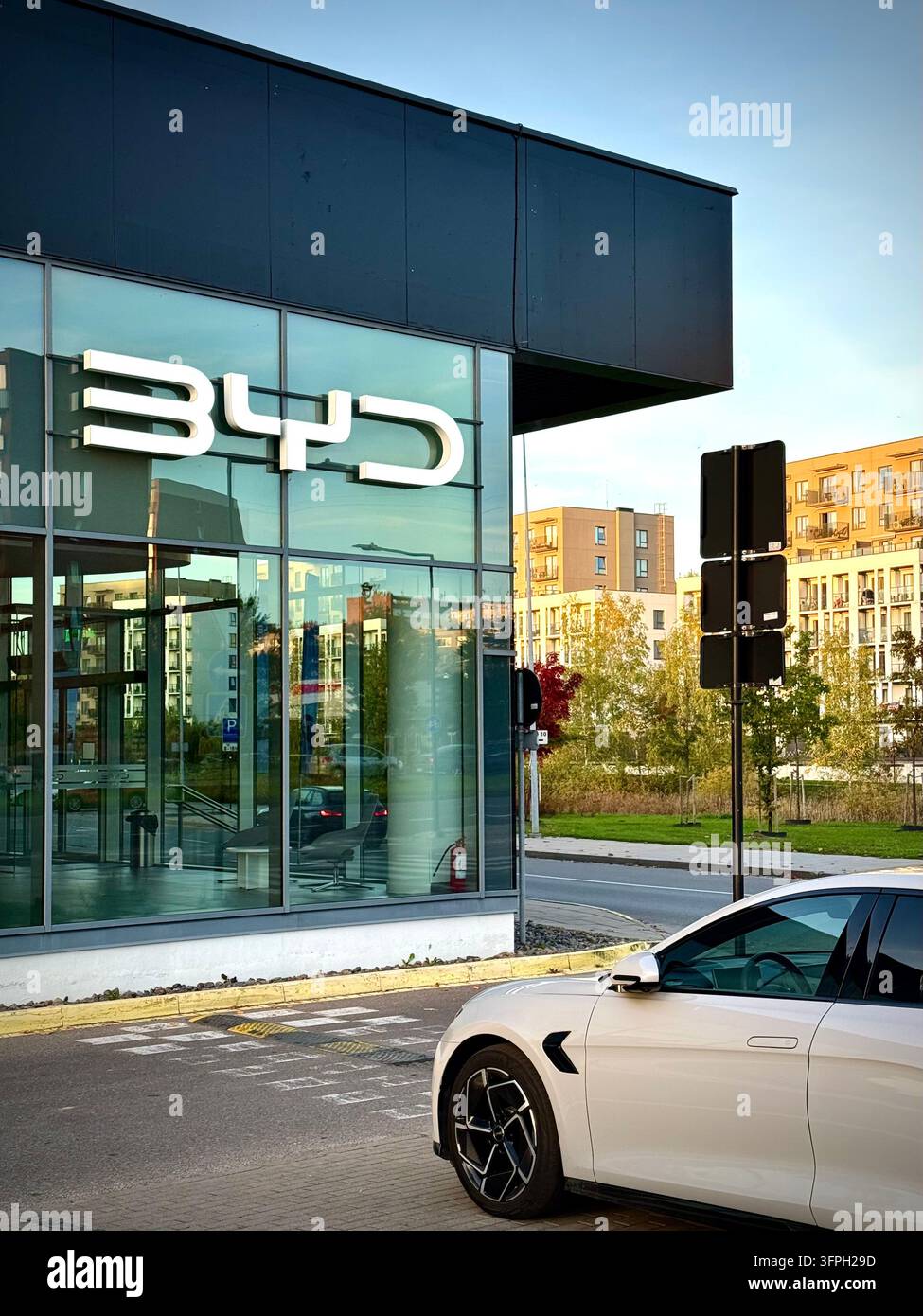 Ein modernes BYD-Autohandelsgeschäft mit weiß beleuchteter BYD-Logo-Schilderei - Smartphone-aufgenommenes Stockfoto