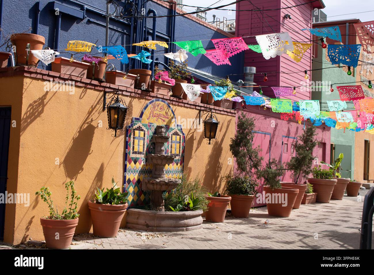 San Antonio, Texas, USA - März 2025: Bunte Papel-Picado-Banner, die über den Innenhof entlang der La-Margarita-Fassade am Historic Market Square gespannt sind. Stockfoto