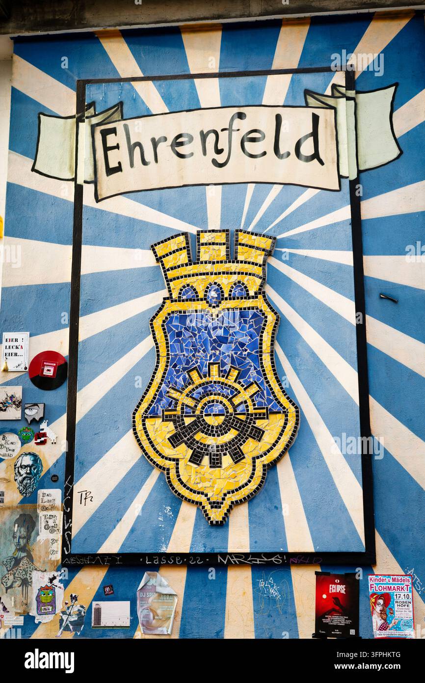 Köln, Deutschland, 02. Oktober 2026: Wandgemälde mit Mosaik-Wappen des Bezirks Ehrenfeld mit Street Art und Aufklebern in Köln, Deutschland Stockfoto
