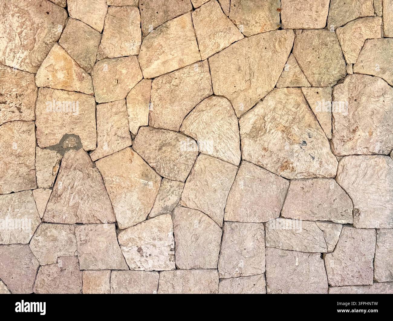Beige Fliesenwandtextur, unregelmäßige polygonale Kalksteinplatten in trockener Mauerwerkverlegung Vollrahmenmuster Stockfoto