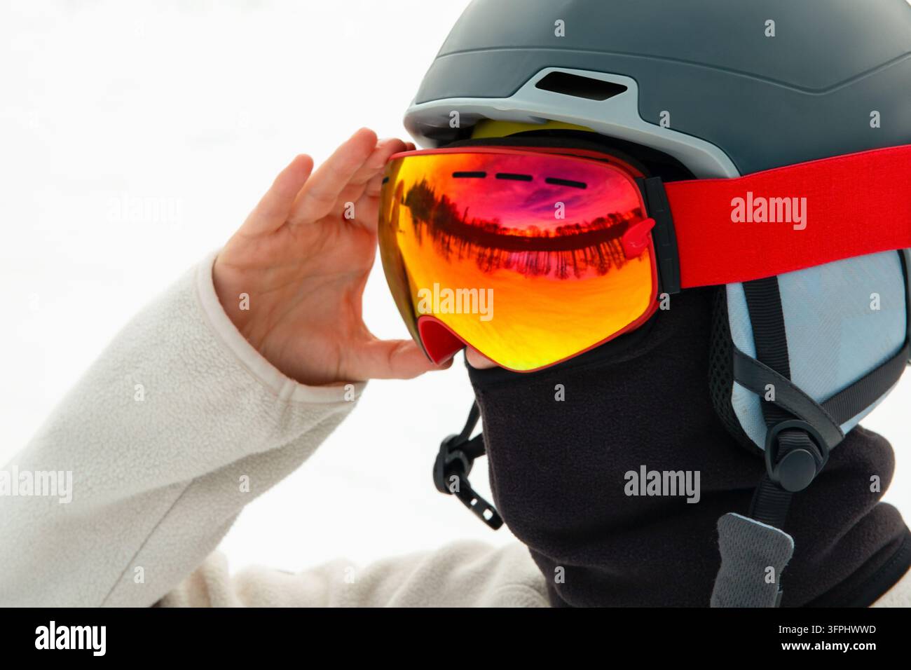 Skibrillen. Skifahrer mit Helm, der leuchtende Skibrillen anpasst, um sich auf einen Tag auf den Pisten vorzubereiten. Skibrillen und Helm Stockfoto