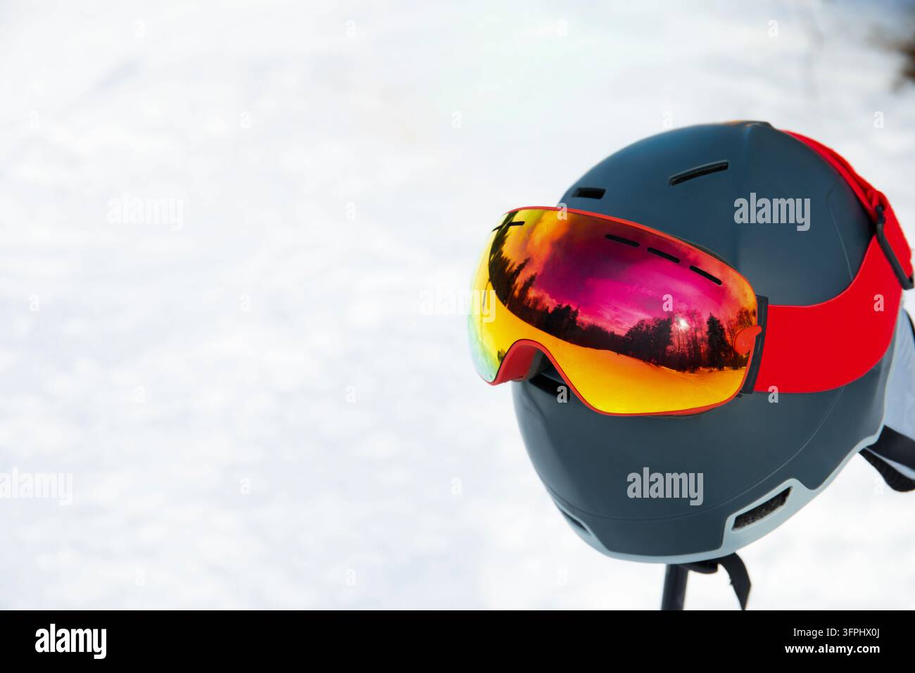 Ski-Ausrüstung. Skihelm und Skibrille auf Schnee in einer ruhigen Winterlandschaft. Skihelm und Skibrille Stockfoto