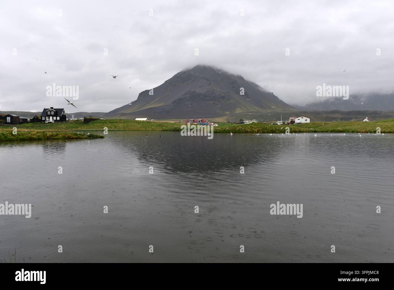 Der Stapafell-Berg spiegelt sich in einem ruhigen See in Arnarstapi in Island wider Stockfoto