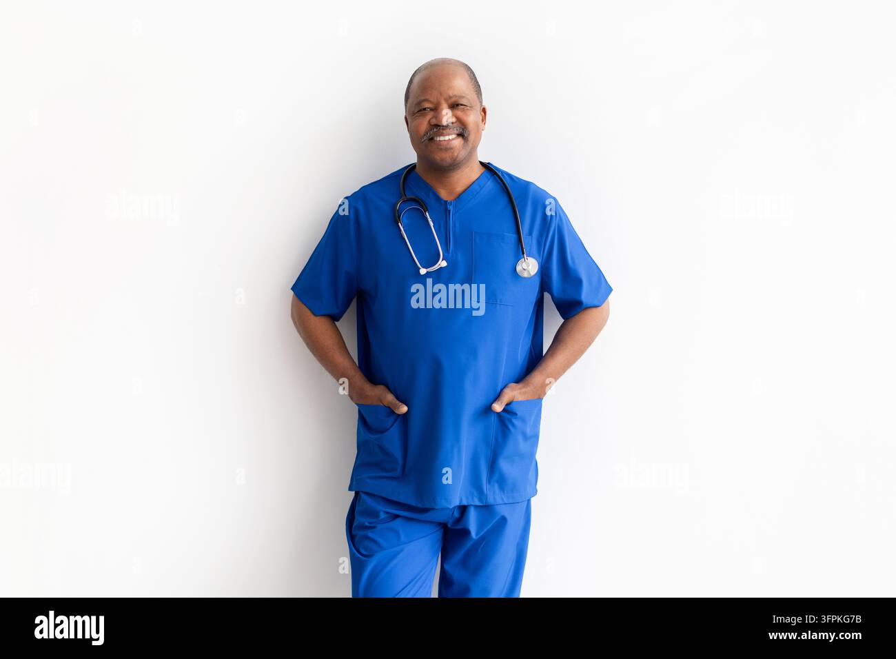 Porträt eines selbstbewussten schwarzen Gesundheitsexperten im höheren Alter, der blaue OP-Kleidung und ein Stethoskop trägt Stockfoto