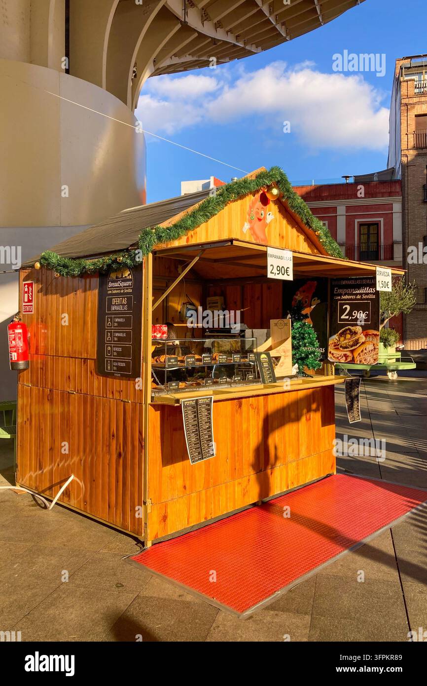 SEVILLA, SPANIEN - 25. DEZEMBER 2025: Ein festlicher Weihnachtsmarkt füllt den Platz unter den ikonischen Setas de Sevilla und schafft eine lebhafte Feierszenen - Smartphone-aufgenommenes Stockfoto