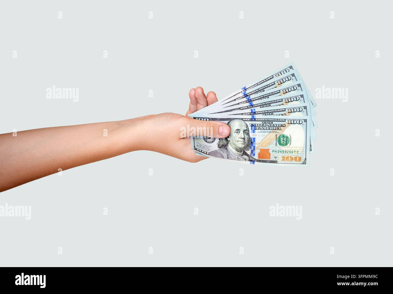 Männerhand hält viele Dollarscheine. Frauenhand mit Dollars, isoliert auf grauem Hintergrund. Männerhand mit Fächer von Dollarscheinen. Konzept von Stockfoto