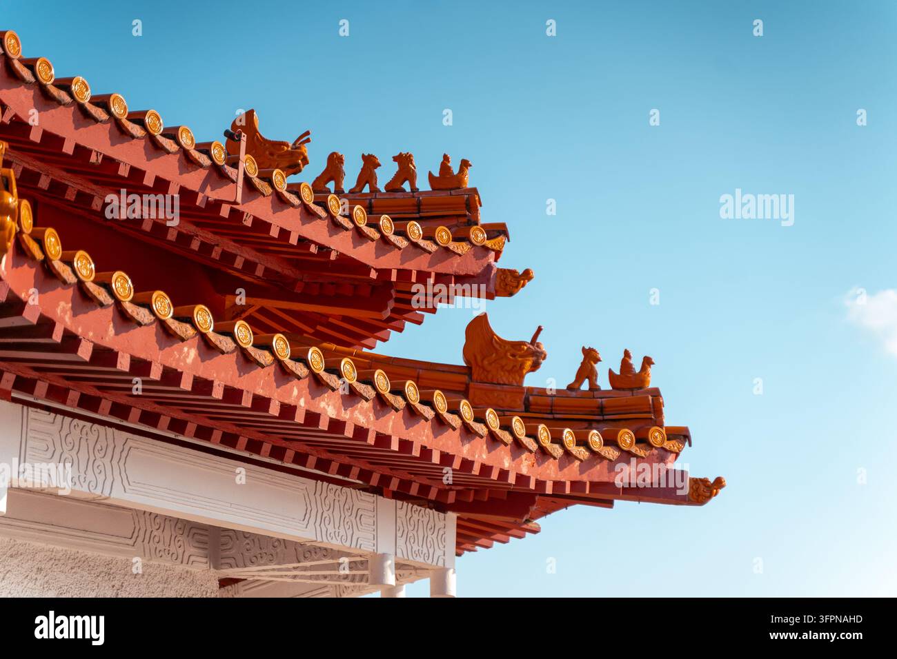 Verzierte glasierten Ziegel und Firstfiguren am Dachgesims eines chinesischen Pavillons vor einem blauen Himmel, Singapur Stockfoto
