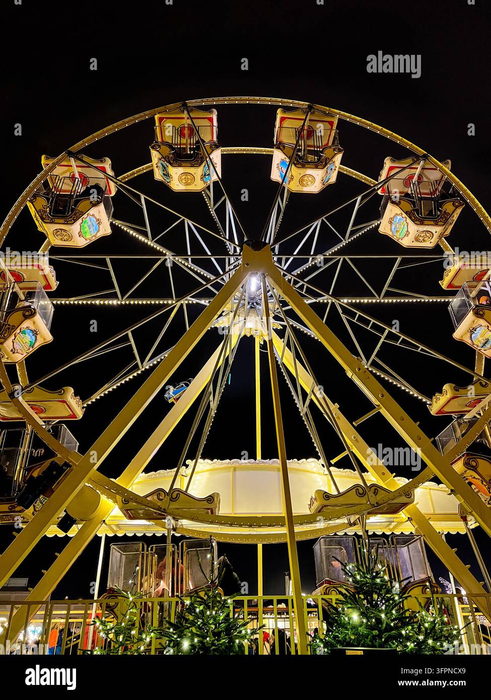 Wien, Österreich - 21. Dezember 2025: Beleuchtetes Riesenrad auf dem Weihnachtsmarkt des Schlosses Schönbrunn in Wien, Österreich. Stockfoto