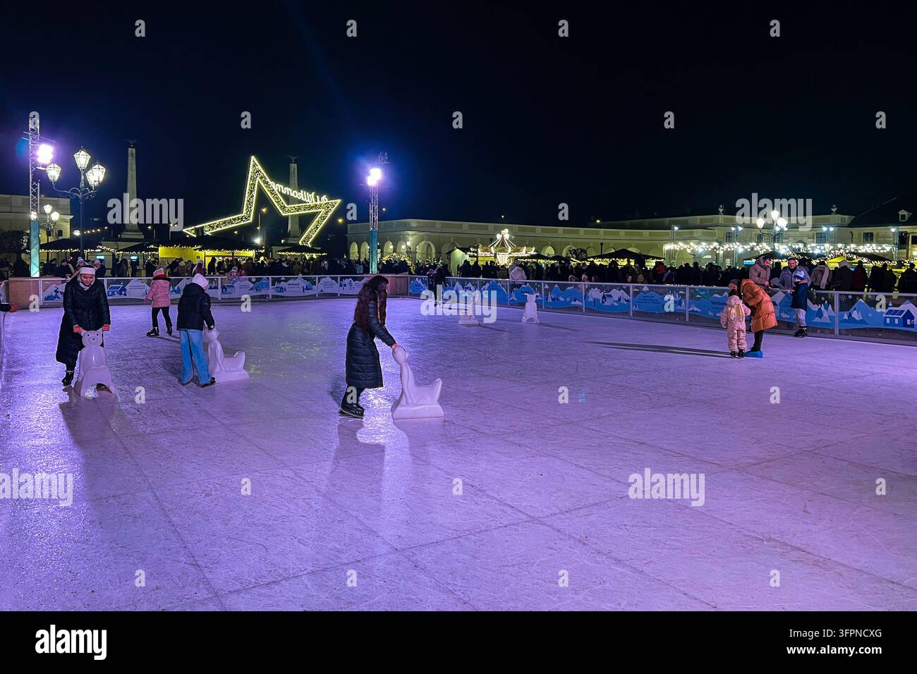 Wien, Österreich - 21. Dezember 2025: Eislaufbahn am Weihnachtsmarkt Schönbrunn in Wien, Österreich an einem Winterabend Stockfoto