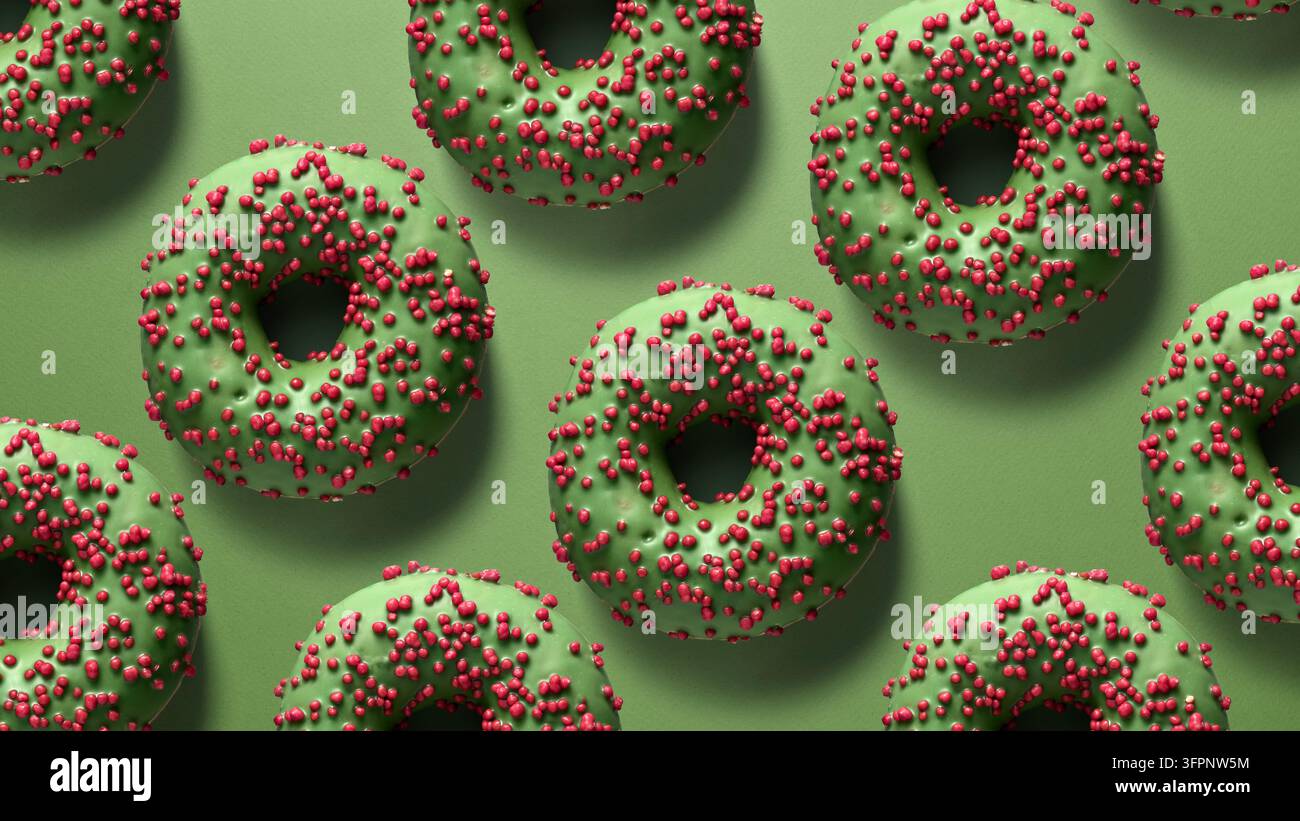 Kreativer Hintergrund mit grün glasierten Donuts, bedeckt mit roten Streuseln auf einer grünen Oberfläche. Ein festliches und modernes Design für kreative Projekte Stockfoto