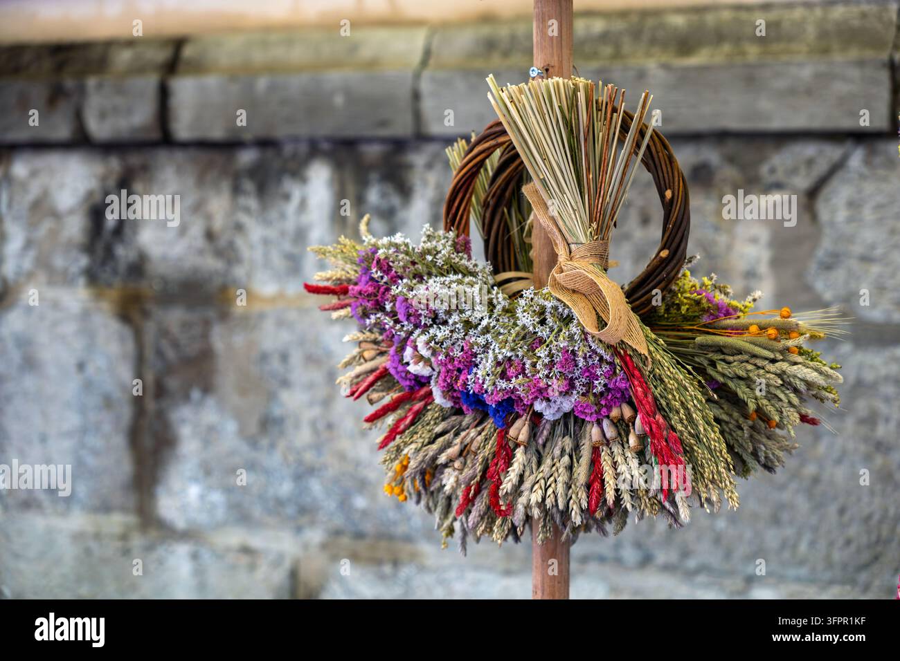 Detaillierte Ansicht eines ukrainischen Erntekranzes (Didukh) mit violetter Statice und Weizen: Kulturelle Symbolik in Bewegung Stockfoto