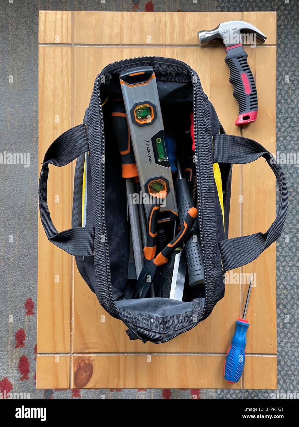 Kleine Leinwand-Werkzeugtasche auf Holzbank für kleine Reparaturen rund um das Haus - Smartphone-aufgenommenes Stockfoto