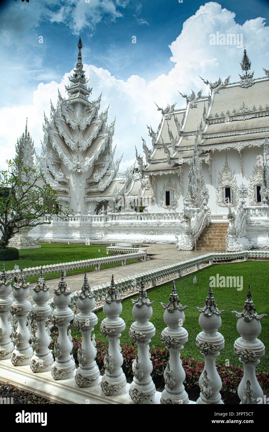 Weißer Tempel mit aufwendigem Design und bewölktem Himmel im Hintergrund, Chiang Rai, Thailand Stockfoto