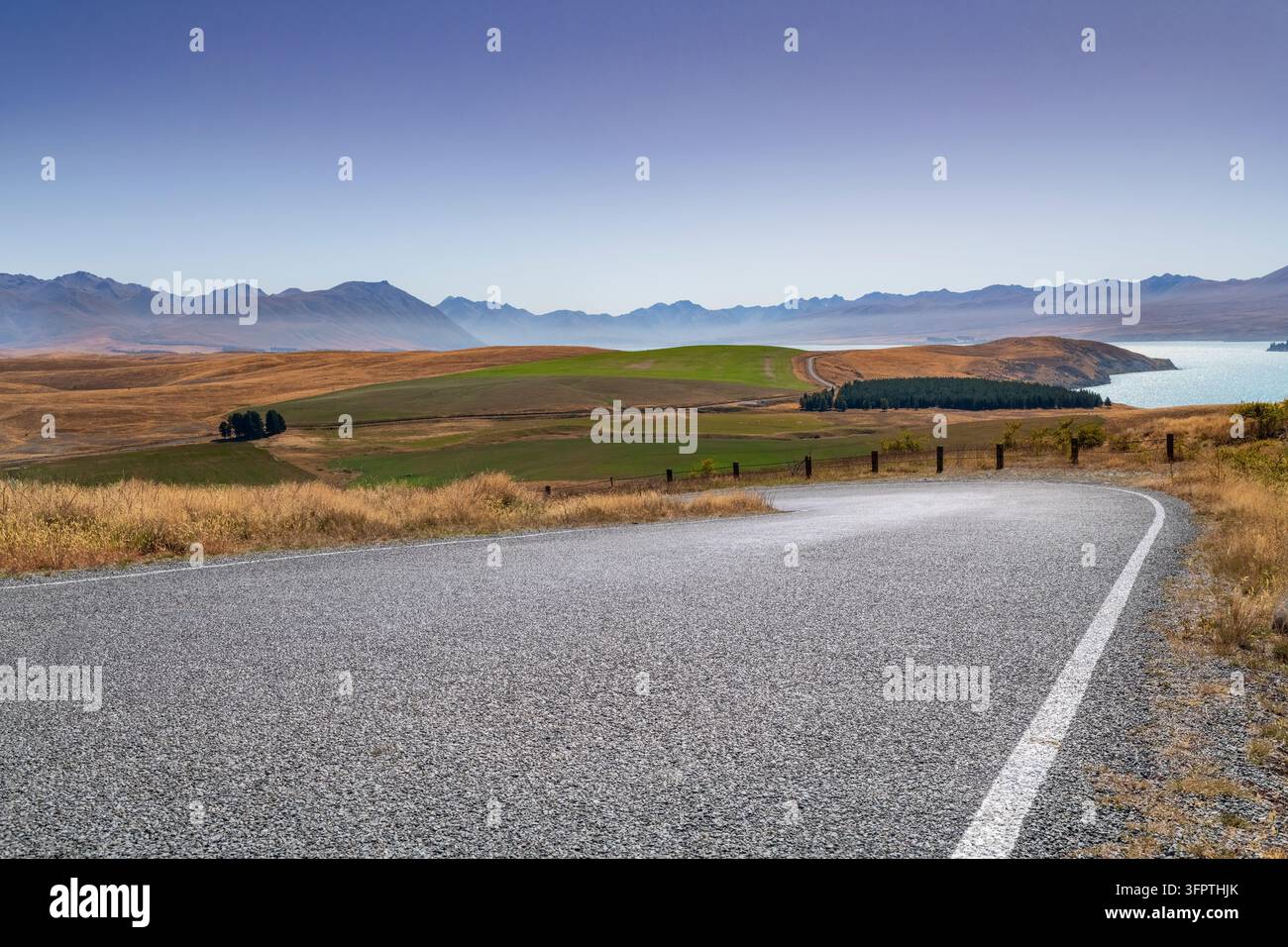 Straßenhintergrund, Automobil-Rückplatte, gepflasterte Haarnadelkurve in einer begehrten ländlichen Landschaft mit weitläufigen Aussichten Stockfoto