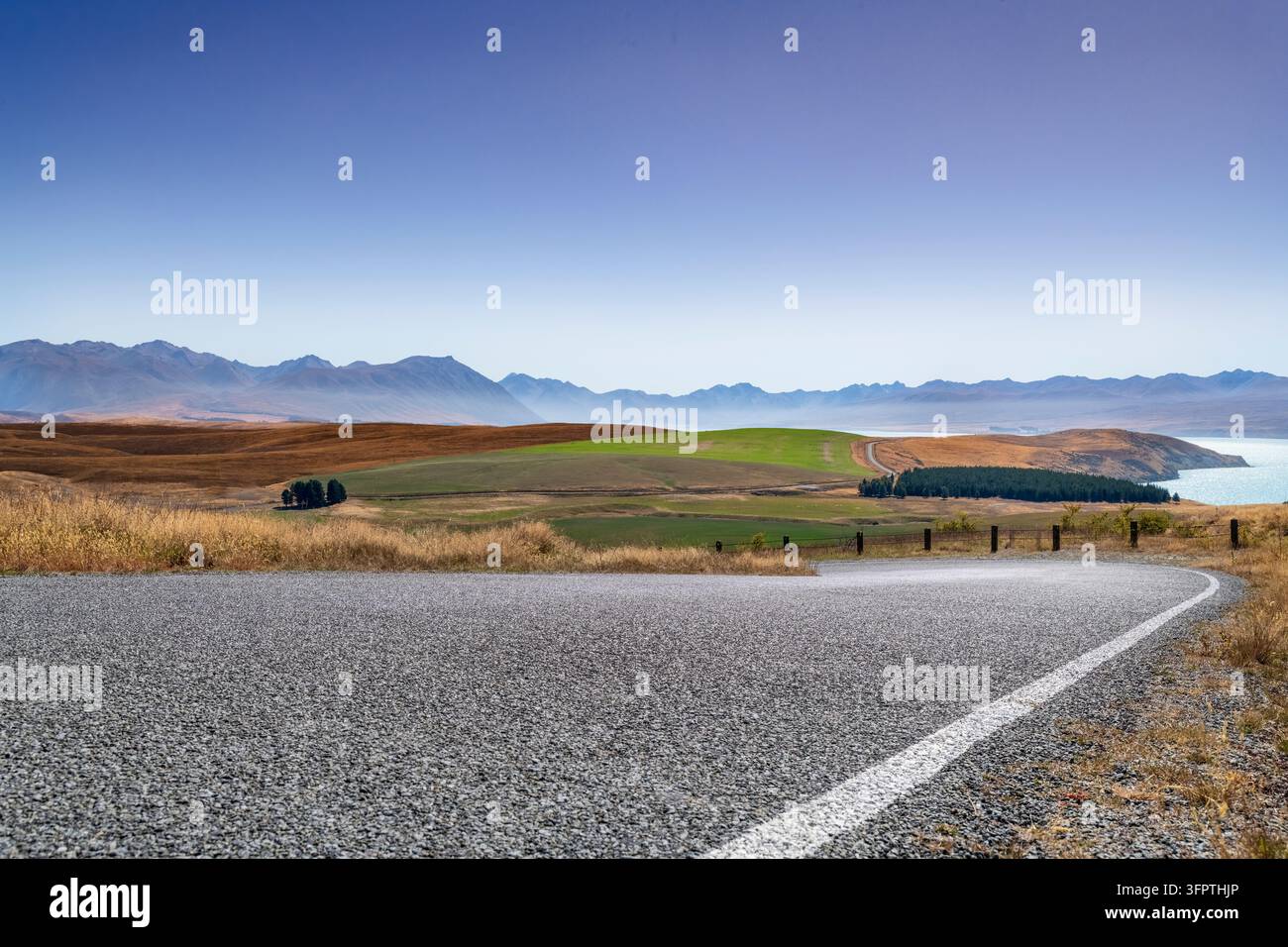 Straßenhintergrund, Automobil-Rückplatte, gepflasterte Haarnadelkurve in einer begehrten ländlichen Landschaft mit weitläufigen Aussichten Stockfoto