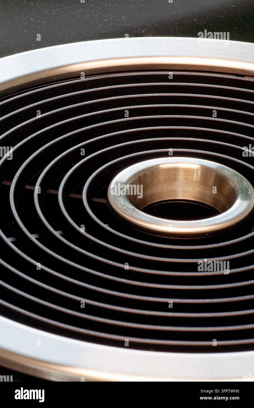 Modernes Dunstabzugssystem, das nahtlos in eine schwarze Induktionskochplatte integriert ist und effiziente Küchenbelüftung sowie ein schlankes, minimalistisches Design bietet Stockfoto