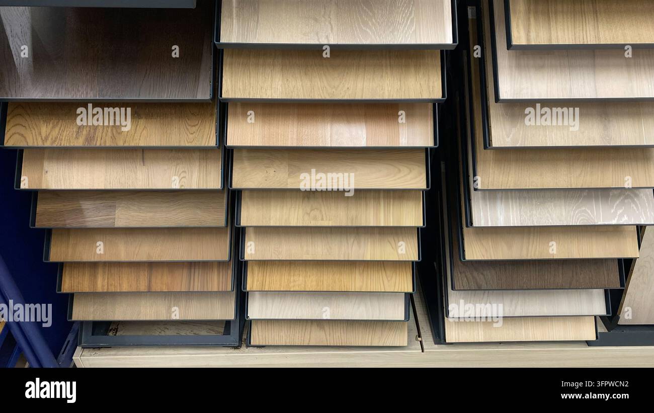 Laminatbodenproben in verschiedenen natürlichen Farbtönen mit Holzoptik, die auf Regalen in einem Baumarkt ausgestellt sind Stockfoto