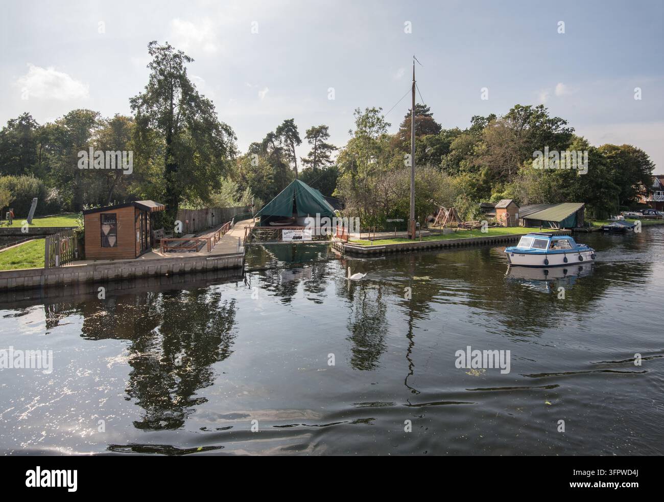 Norfolk Broads Nationalpark mit Wasseranlegeigenschaften entlang des Flusses Bure nahe Wroxham. Viele mit eigenen Liegeplätzen. Stockfoto