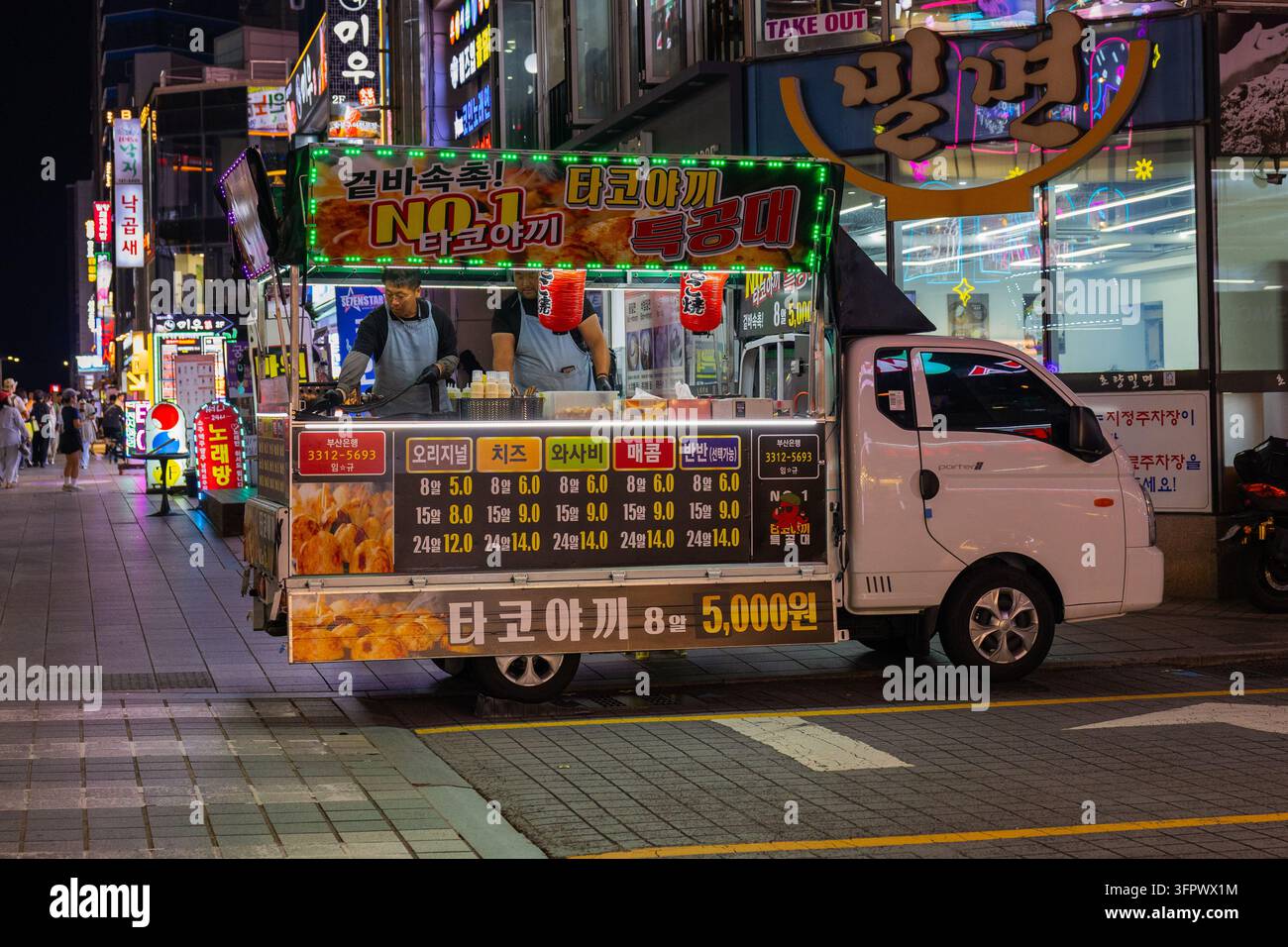 Südkorea, Busan – 21. Sep 2026: Takoyaki-LKW mit zwei Köchen auf einer Nachtstraße in Busan, Südkorea Stockfoto